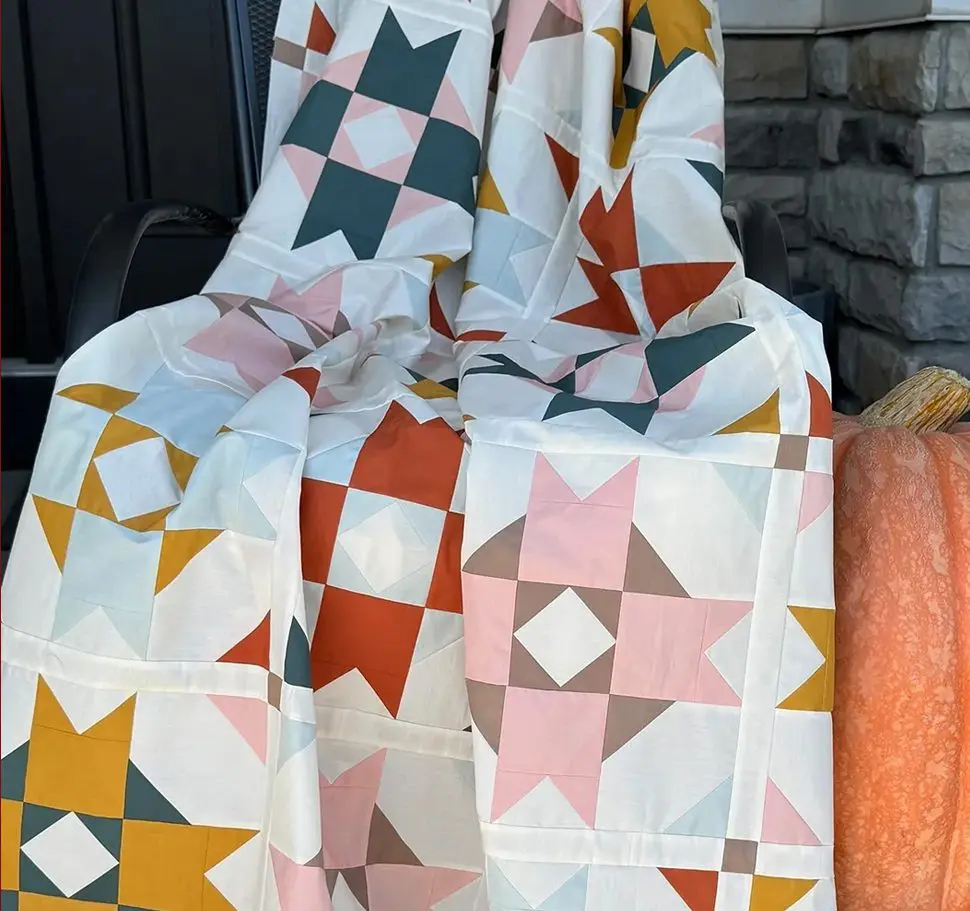 A quilt sitting on top of a blanket.